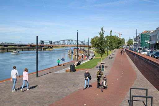 De IJsselkade op een zonnige dag, met de Oude IJsselbrug op de achtergrond